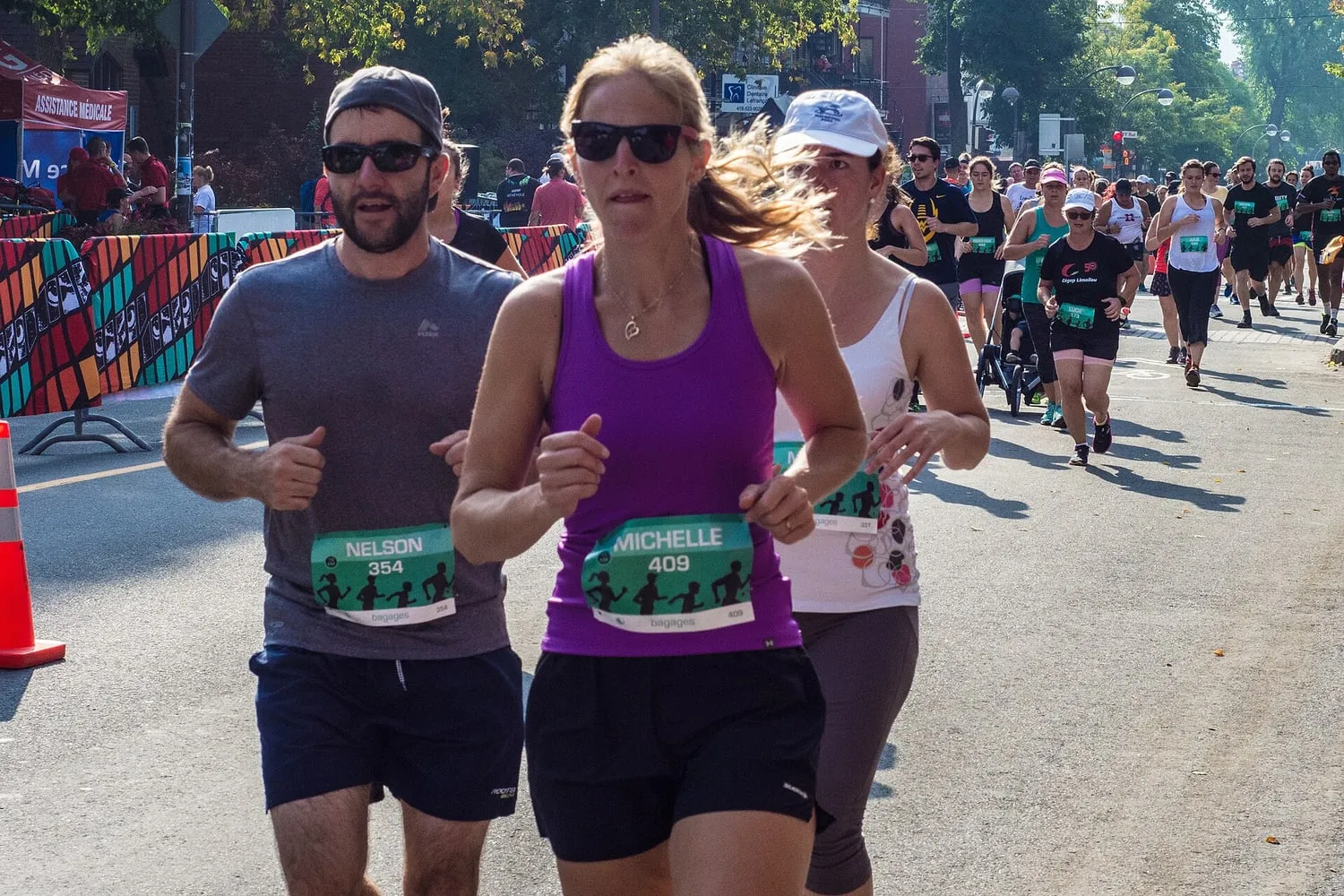 Runners in light summer clothing during a road race on a sunny street