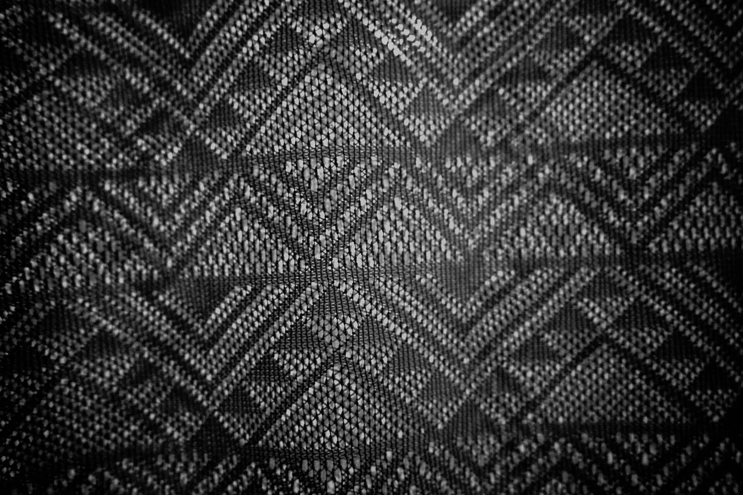 A woven fabric photographed with light shining through it