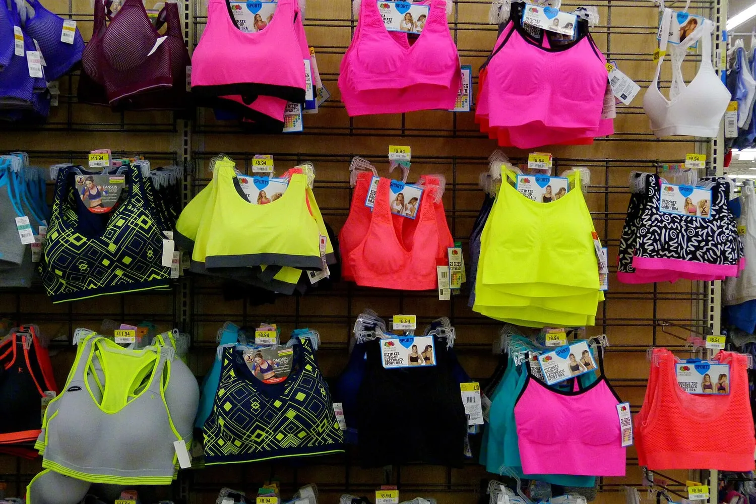 Rows of brightly coloured sports bras on display in a shop